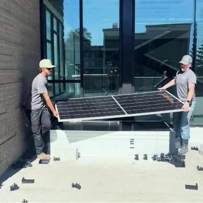 Greenbox Solar commercial services three men standing on solar panels large building